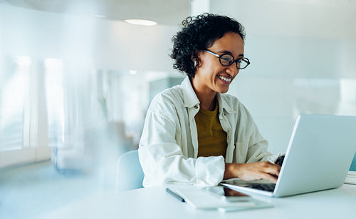 Woman using laptop in office smiling at work