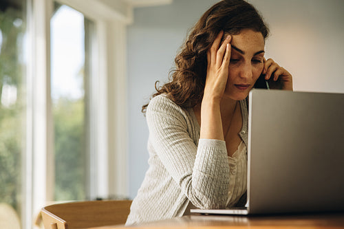 Woman looking stressed out while working from home