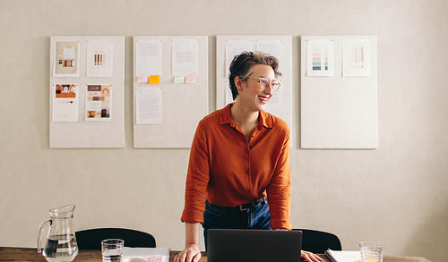 Happy interior designer looking away with a smile in a creative office