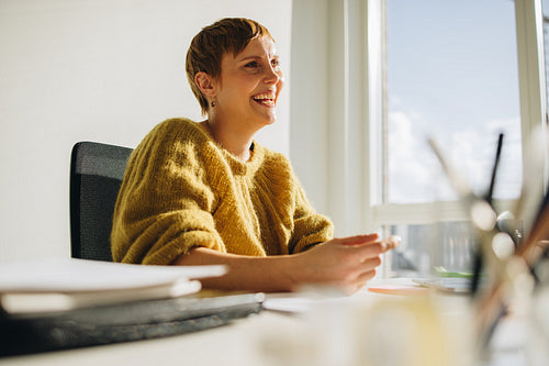 Happy female executive sitting at desk