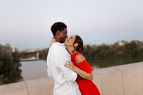 Carefree couple laughing happily on a bridge