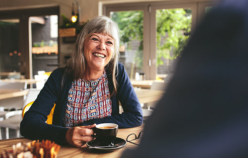Happy mature woman at coffee shop