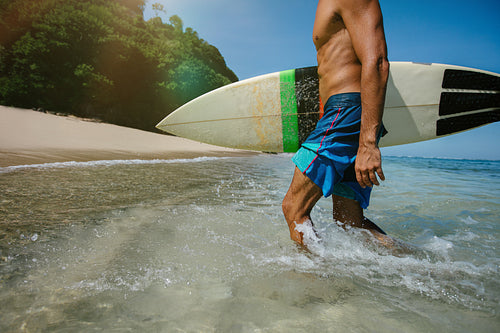 Male surfer walking out of the ocean