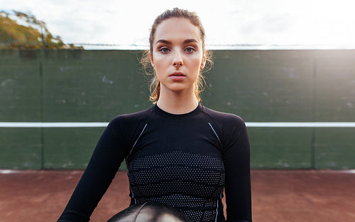 Portrait of young sportswoman on tennis court