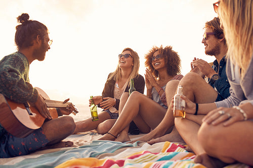 Group of smiling friends having fun at the beach