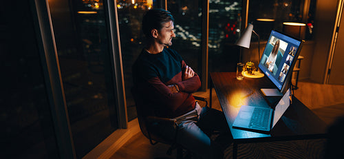 Professional businessman having a virtual meeting with his colleagues at night