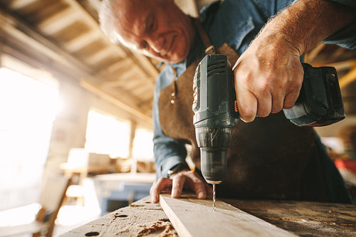 Drilling a hole on wooden plank