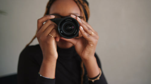 Cheerful female photographer smiling and taking pictures