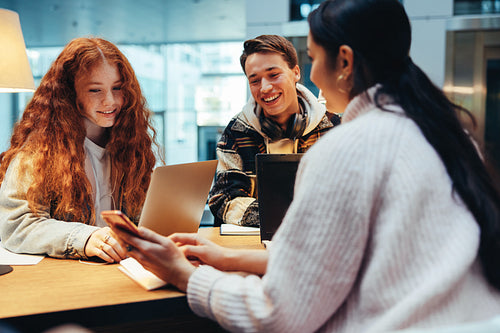 Students using a cell phone in library