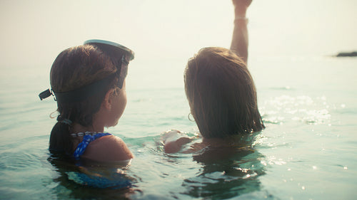 Mother and daughter share happy vacation moments snorkeling together in the clear tropical ocean