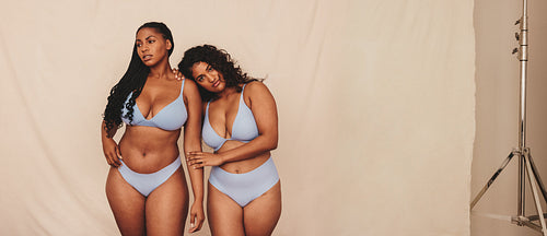 Body positive young women wearing blue underwear in a studio