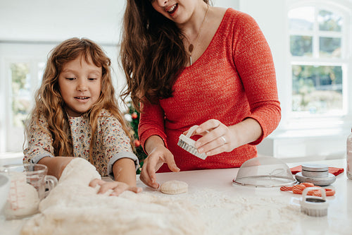 Mother and daughter preparing Christmas cookies.