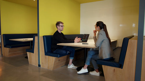 Two software developers having a discussion in a coworking office