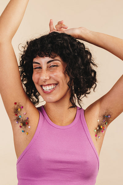 Unshaven young woman flaunting her confetti-decorated underarms