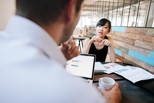 Two businesspeople discussing work in office