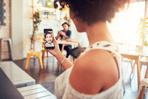 Woman having a videochat with man on mobile phone.