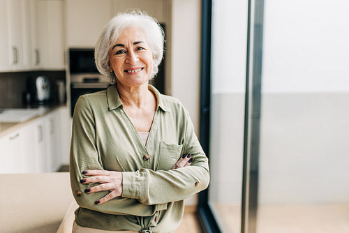 Elderly woman smiling happily inside her home