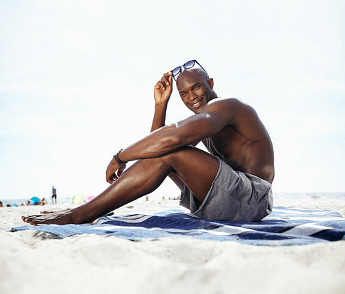 Handsome young man sitting on beach