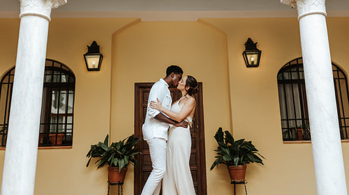 Young couple kissing affectionately on a porch