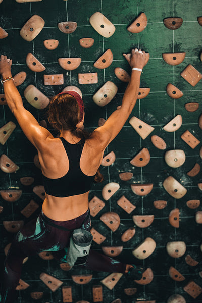 Woman climbing indoor boulder wall