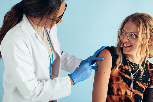 Woman getting vaccine on arm from a doctor
