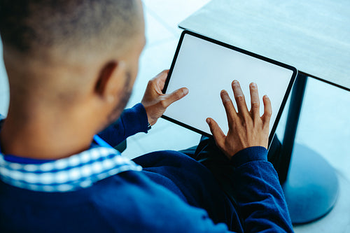 Businessman using a blank tablet in modern office setting