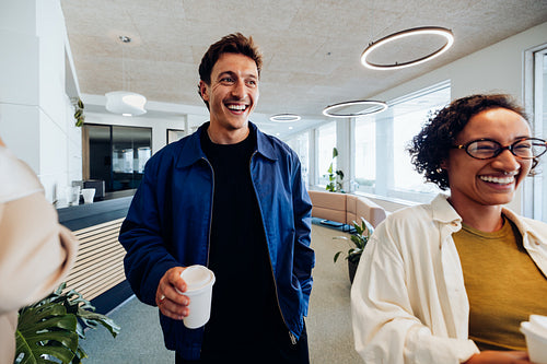 Two colleagues share smiles in office lounge