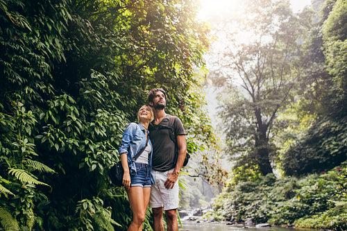 Couple standing by stream in woods