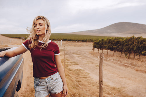 Woman on road trip standing by a truck