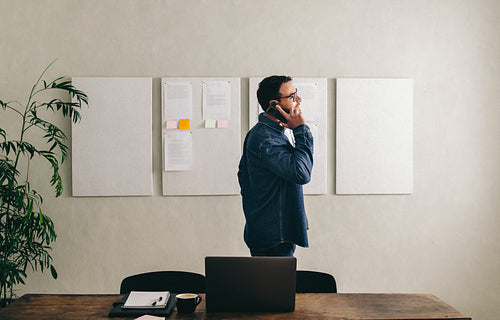 Young businessman talking on the phone in a creative office