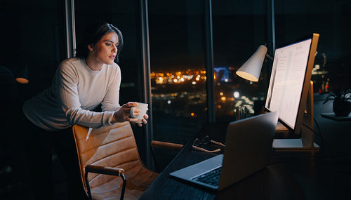 Pensive businesswoman working with a computer in her home office, strategising a project