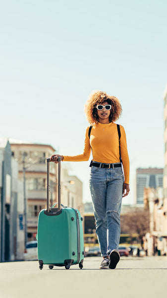Woman tourist walking on street with luggage