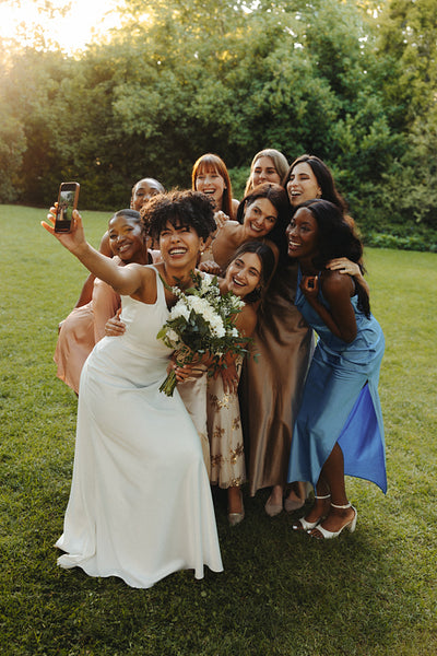 Bride taking a fun selfie with bridesmaids on a sunny wedding day