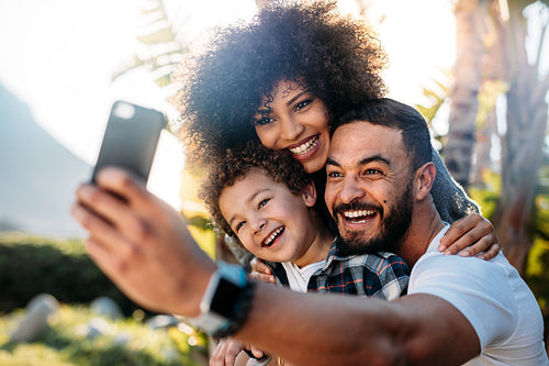 Smiling man taking a selfie with wife and kid