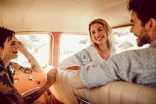 Young friends traveling by a car