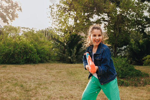 Happy child playing in a garden with a water toy on a sunny day