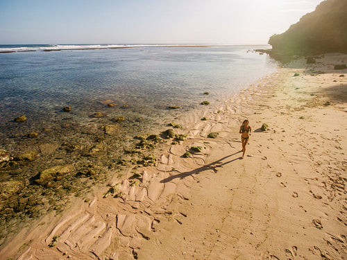 Tropical beach with a woman running