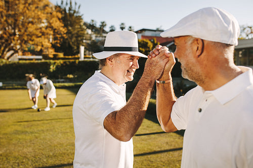 Senior people playing boules in a park