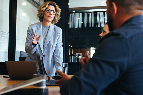 Team leader having a discussion with her colleagues. Business woman leading her team on a project