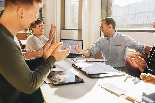 Team appreciating suggestions of young executive in meeting