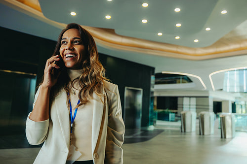 Confident Indian lawyer on phone in modern office lobby