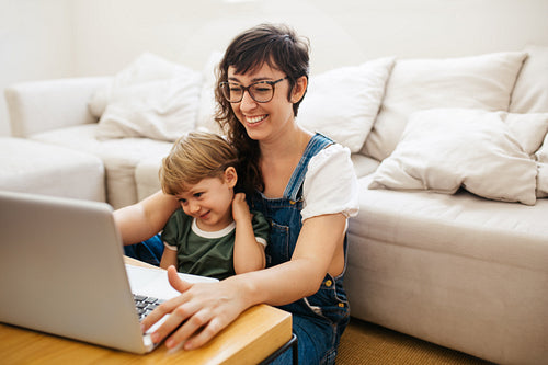 Mother working from home with son