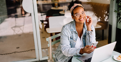 Business woman using laptop and smartphone in cafe