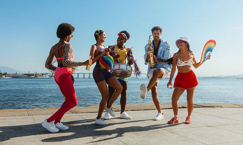 Friends dance on the docks during Brazilian carnival.