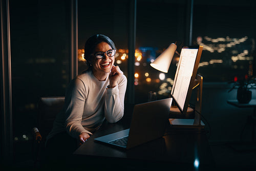 Business woman smiling at camera in her office at night