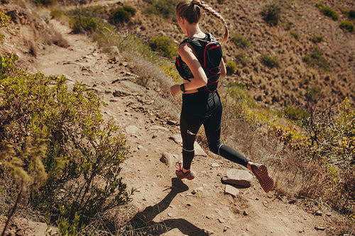 Woman running on rocky trails in mountains