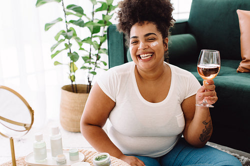 Woman enjoying wine during skin care treatment at home