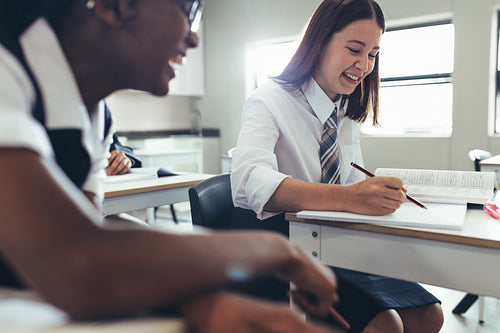 Students smiling in classroom while studying