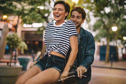 Happy couple on bicycle in the city