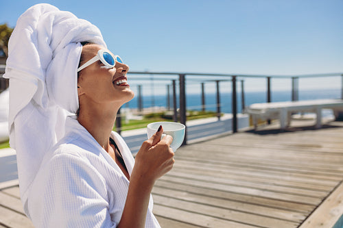 Woman at poolside having coffee after a swim